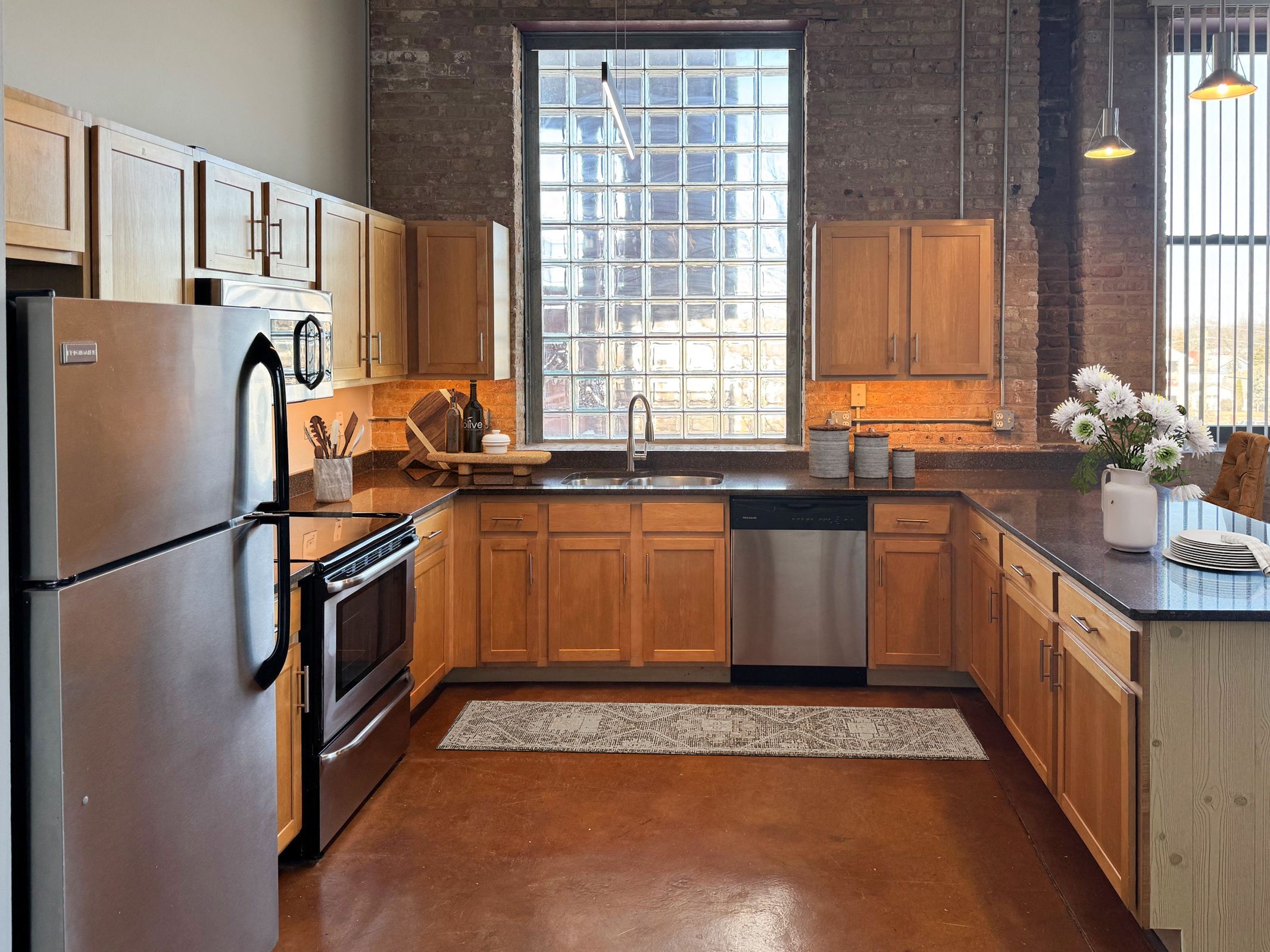 A kitchen with wooden cabinets and a large window.